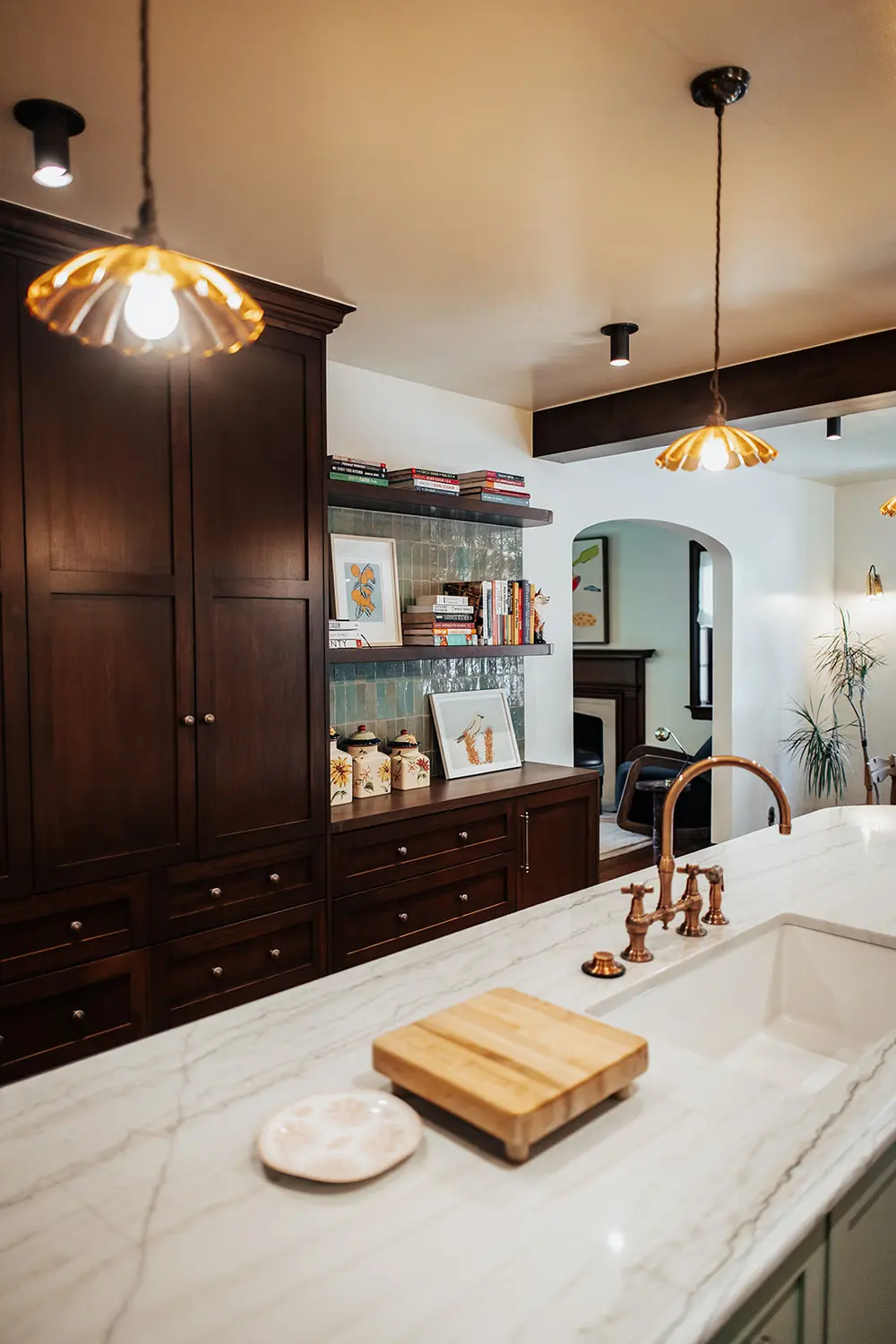Marble waterfall island with brass faucet and custom cabinetry in an award-winning Salt Lake City kitchen