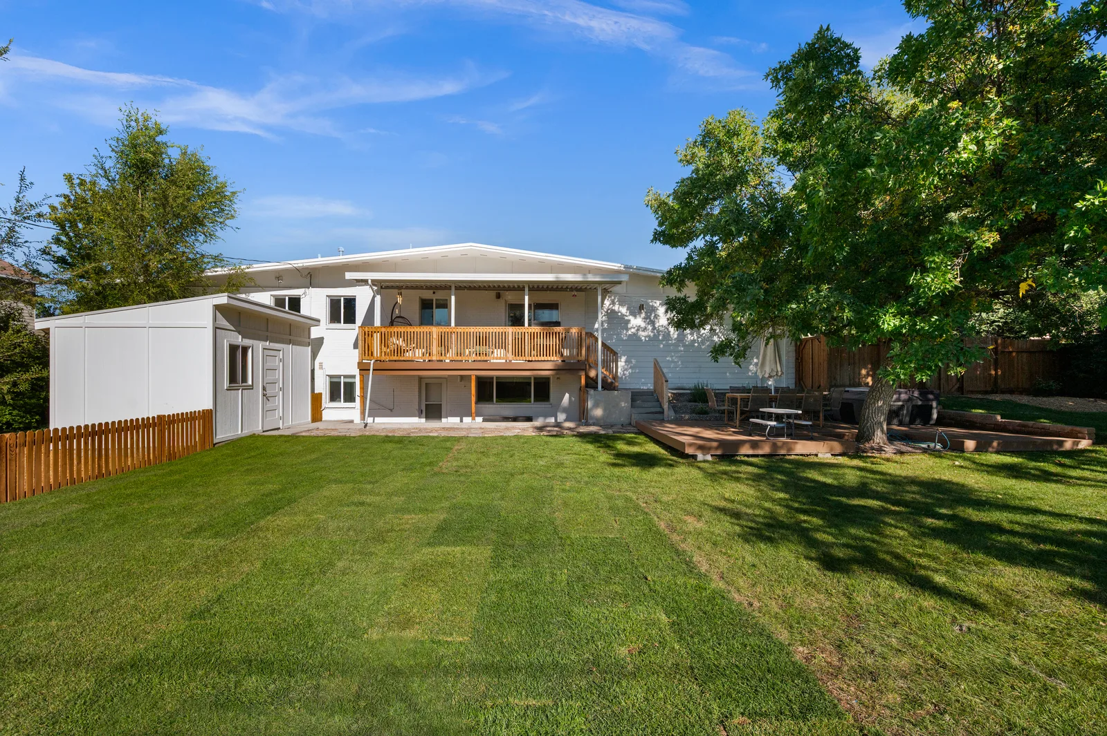 Large landscaped backyard behind a remodeled single-story mid-century ranch in Holladay, Utah