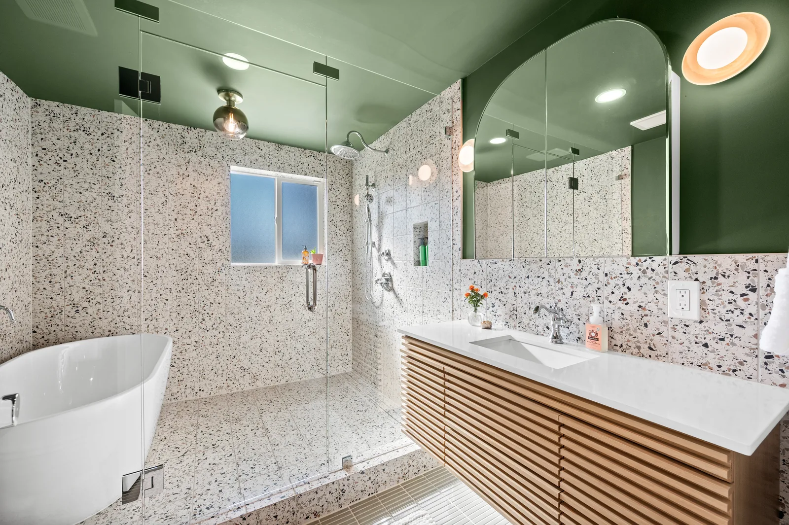 Terrazzo guest bathroom with a freestanding tub, floating vanity, and glass shower in a luxury Holladay remodel